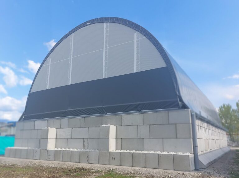 Buitenaanzicht boogloods bij asfaltcentrale