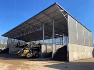 Buitenaanzicht industriële luifel met vaste stofschermen bij grondrecyclage