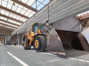 Detailfoto van mammoetpoort met bulldozer in meststoffenopslag