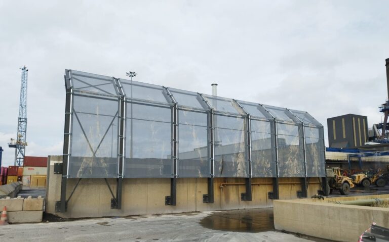 Stofmuur rond opslagboxen op openlucht recyclage site foto 2