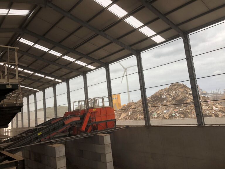 Binnenaanzicht recyclagehal met stofschermen bij houtschredder installatie
