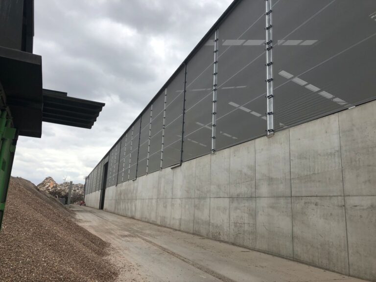 Buitenaanzicht recyclagehal met stofschermen bij houtschredder installatie – foto 3