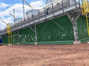 Groene windschermen rondom industriële aircoolers voor optimale luchtstroming, windreductie en energie-efficiëntie van koelinstallaties.